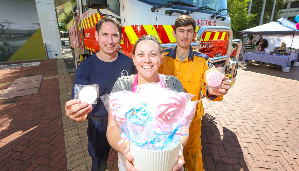 BAKING BONANZA: Lavington Rural Fire Brigade members Tasman Willis and Kristopher Locke help baker Hannah Partl at the fundraiser. Picture: JAMES WILTSHIRE