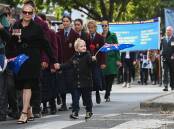YOUTHFUL PARTICIPANT: Oscar Smith-Littlehales, 5, waves his Australian flag as he walks down Albury's Dean Street during Monday's Anzac Day march. Picture: MARK JESSER