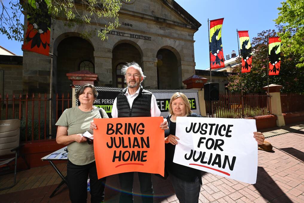 SIGNS OF THE TIMES: Julian Assange's father John Shipton meets with Benalla pair Helen Foster and Jenny Doxey at Wednesday's rally on Dean Street, Albury. Picture: MARK JESSER