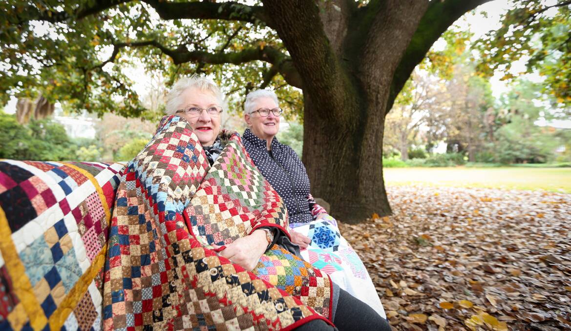 COSY CRAFT: Murray River Quilters treasurer Margaret Parkinson and president Maureen Jones appreciate the warmth of quilts on a cold winter day. The group will host its biennial Quilt-In on July 6. Picture: JAMES WILTSHIRE 