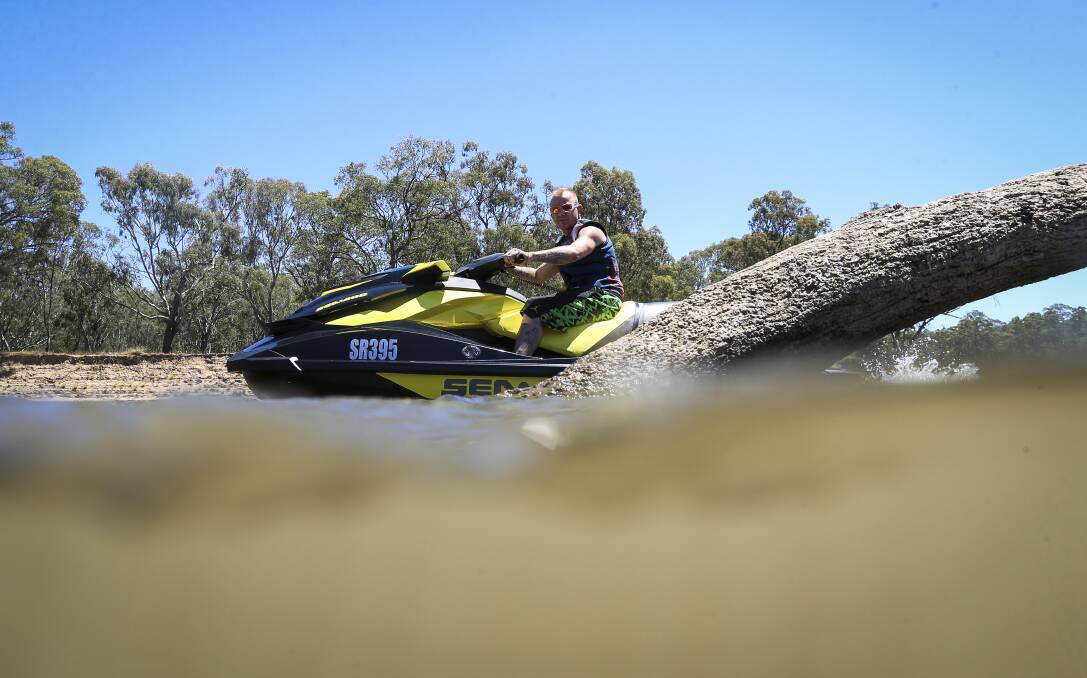 TAKING CARE: Melbourne holiday-maker Chris Carlin rides warily on his jet-ski to avoid logs in the water on Wednesday. Picture: JAMES WILTSHIRE