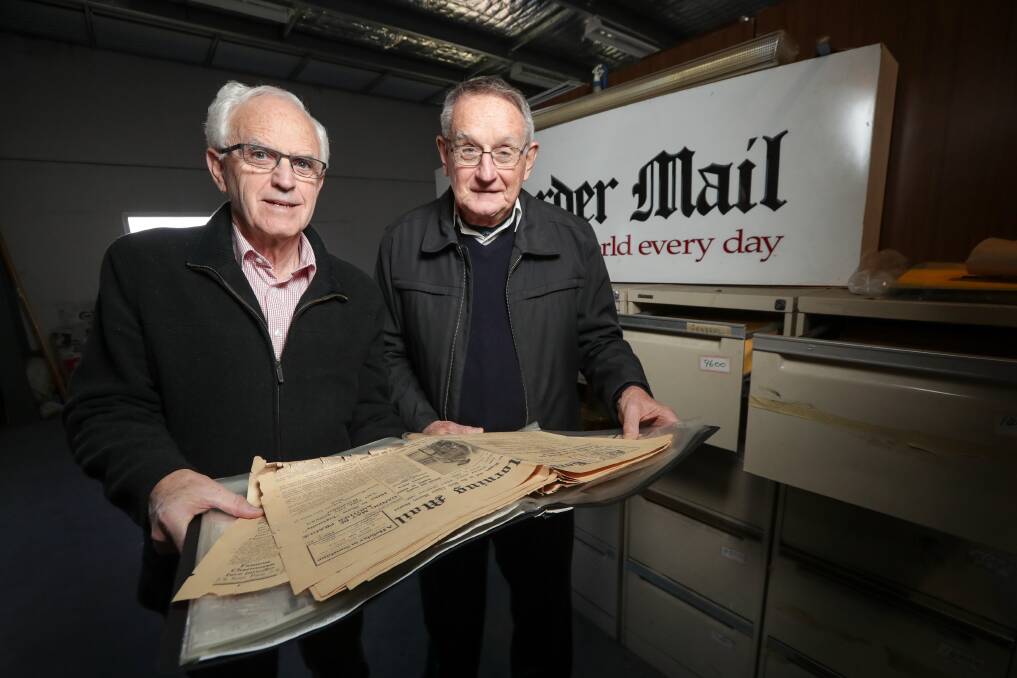 GLIMPSE INTO PAST: Albury and District Historical Society president Greg Ryan and historian Dr Bruce Pennay look over a copy of The Border Morning Mail from 1939.