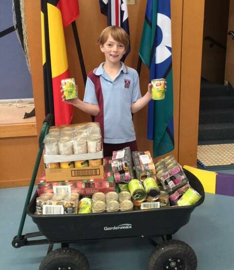 MUCH MORE THAN ONE: Wodonga Primary School's Jye Webb with the 207 cans he donated to the One Can Challenge. The Year 4 student put in $80 of his pocket money.