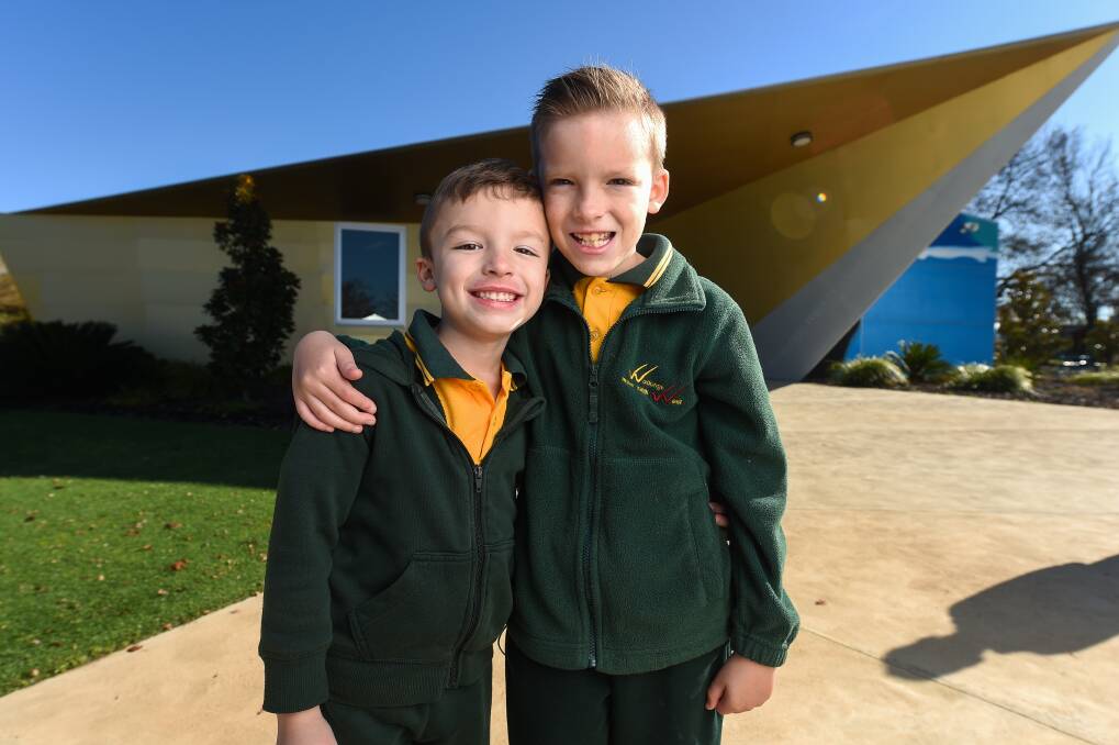 HAPPY PAIR: Wodonga West Primary School year 1 student Caeleb Guthridge, 6, welcomes his older brother Keiran, 9, of grade 4, back to the schoolyard. Picture: MARK JESSER