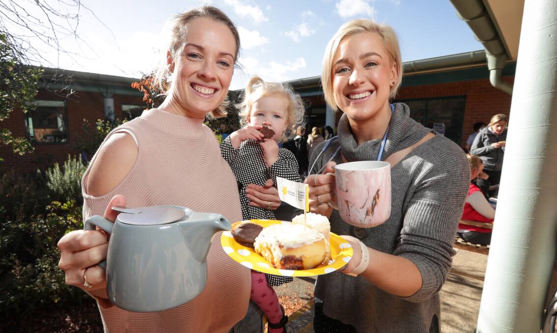 TIME FOR A CUPPA: Alana Wilson, with Halle, 1, and Maddi Bullock enjoy some light refreshments at Albury hospital on Thursday. The combined fundraiser collected more than $300 for the Cancer Council. Picture: JAMES WILTSHIRE
