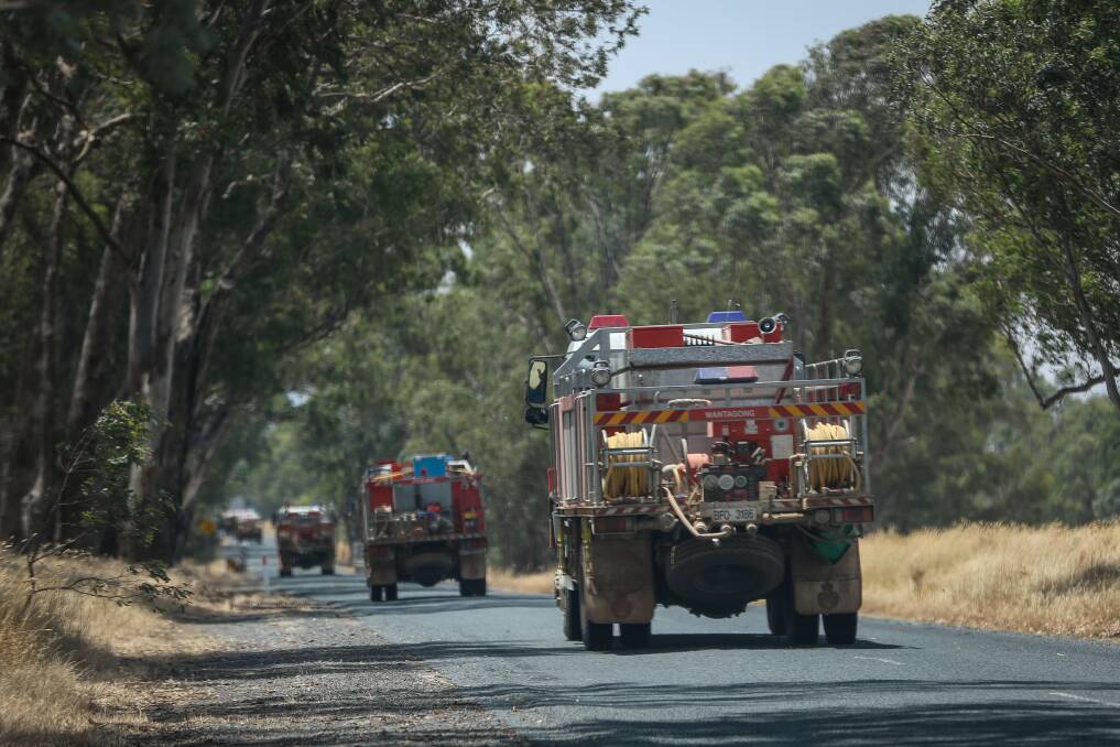 ON DUTY: Fire trucks head down the road at Wantagong, near Holbrook, on Saturday. Picture: JAMES WILTSHIRE
