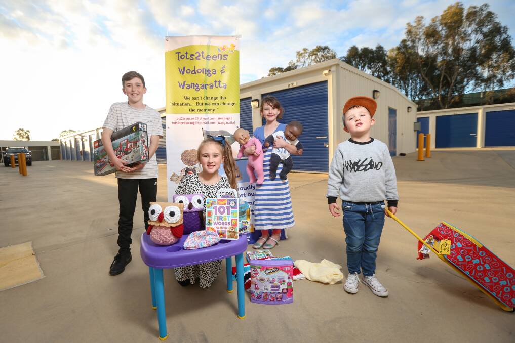 KIDS HELPING KIDS: Harry Knight, 13, Ava Collins, 7, Caity Knight, 8, and Hugh Collins, 4, with some of the new items Tots2Teens provides for children in need. Picture: JAMES WILTSHIRE
