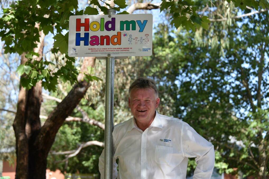 SAFETY FIRST: Federation Council mayor Patrick Bourke stands with the Hold My Hand campaign sign installed at Bangerang Park, Corowa.