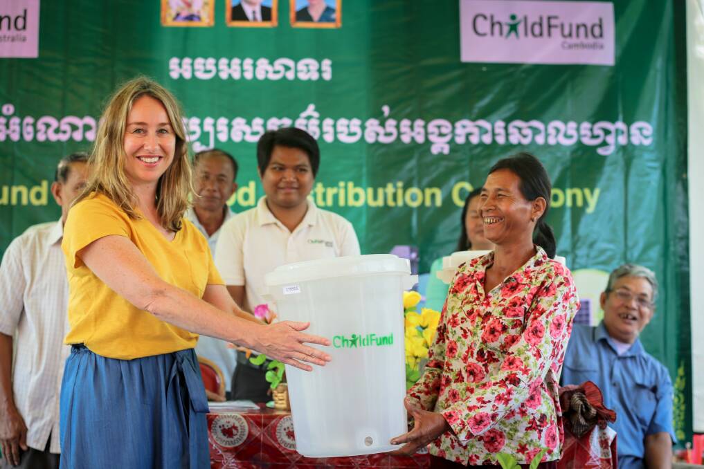HAPPY TO HELP: Melinda Cox (left) presents a water filter at a ChildFund Australia Gifts for Good ceremony in rural Cambodia.
