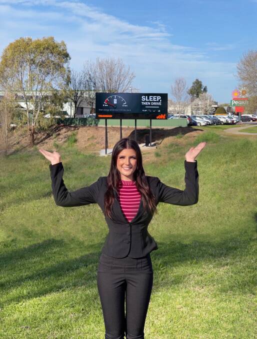 LOCAL IMPACT: Sasha Price stands in front of the Wodonga billboard displaying her road safety message.