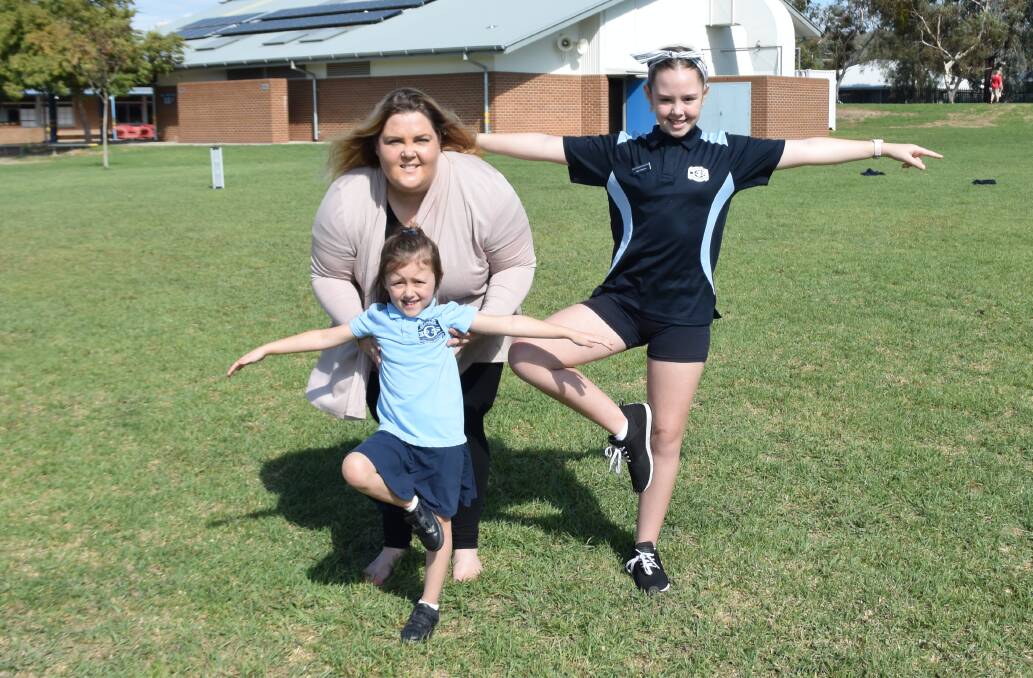 SOMETHING NEW: Mindful Warrior Anna Gannon, of Wagga, guides Glenroy Public School students Lily Randal, 5, and Miah Fitzpatrick, 11, through some yoga positions.