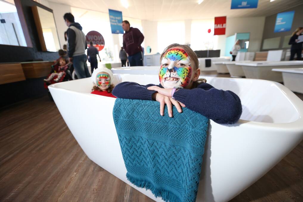 OPENING DAY: Claire Jarvis, 7, of Wodonga, and her little sister Lucy, 2, try out one of the bathtubs on display at the new Highgrove Bathrooms store. Picture: JAMES WILTSHIRE