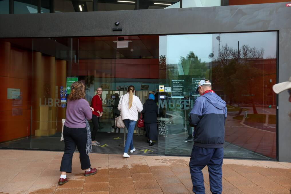 WELCOME BACK: Albury Library Museum staff members oversee the doors opening on Monday morning. Picture: TARA TREWHELLA