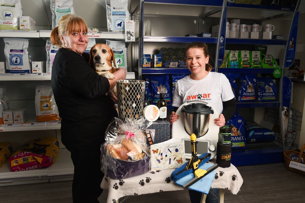 PLENTY ON OFFER: Albury Wodonga Animal Rescue and Albury Cat Rescue's Sonja Brandt and Emily Folker, with dog Max and some of the products. Picture: MARK JESSER
