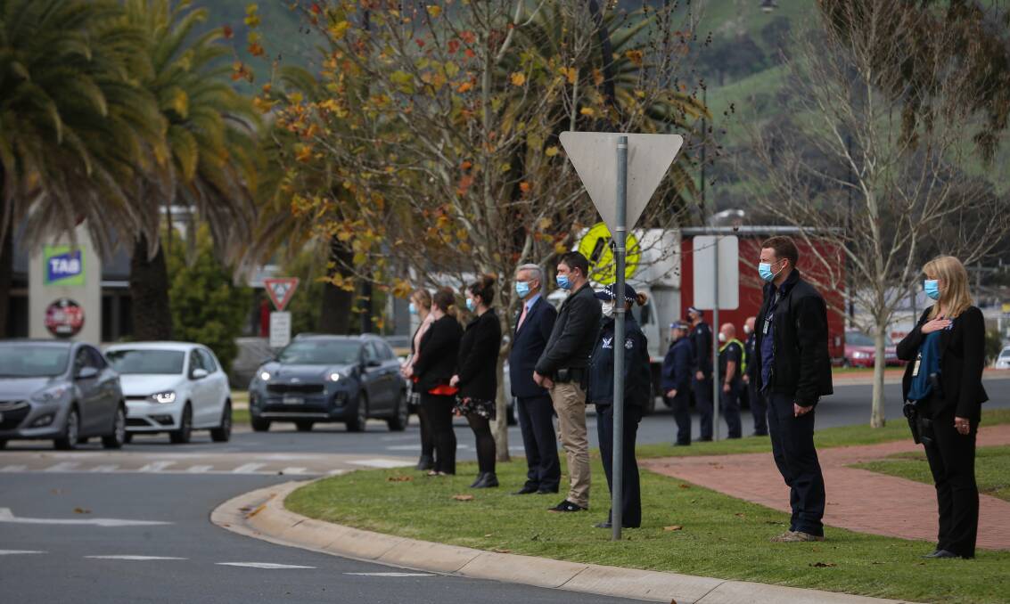 PAYING TRIBUTE: Unable to gather together for a funeral, Wodonga police personnel form a guard of honour for Mr Corcoran in the street. Picture: JAMES WILTSHIRE