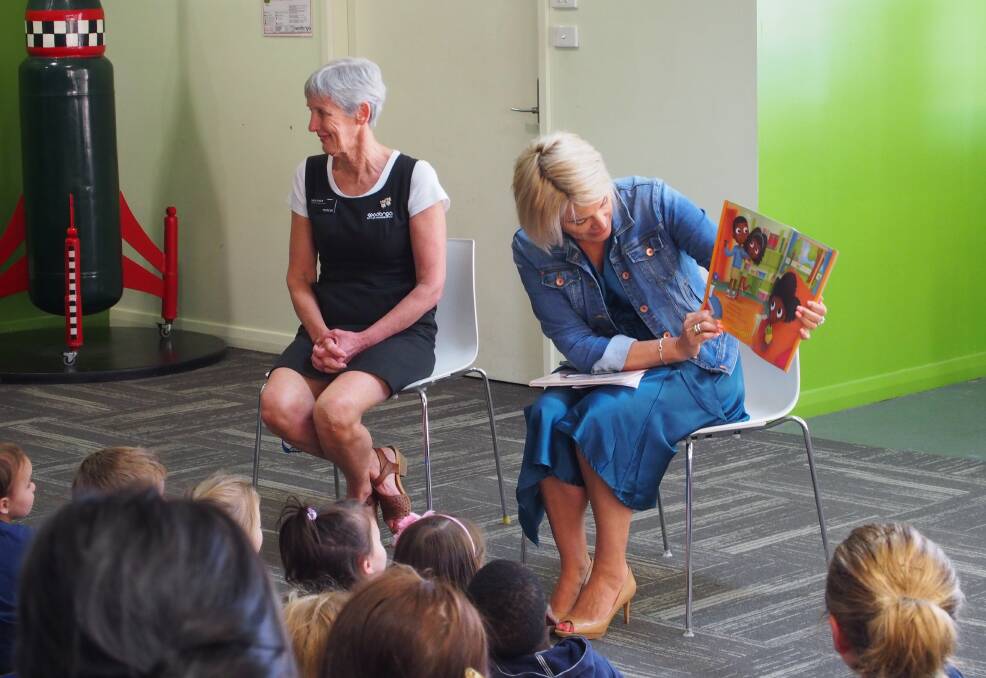 FINDING TIME TO READ: Wodonga mayor Anna Speedie shares a book with a group of children as they say goodbye to the city's library on Hovell Street.