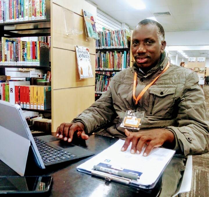 READY TO ASSIST: Clement helps the Congolese community apply for border crossing permits at Wodonga Library this week. Picture: FACEBOOK