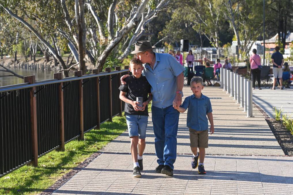 Elenor's partner Simon and sons Charlie and Eli share a special moment during the memorial at the southern end of Hovell Tree Park. Picture by Mark Jesser