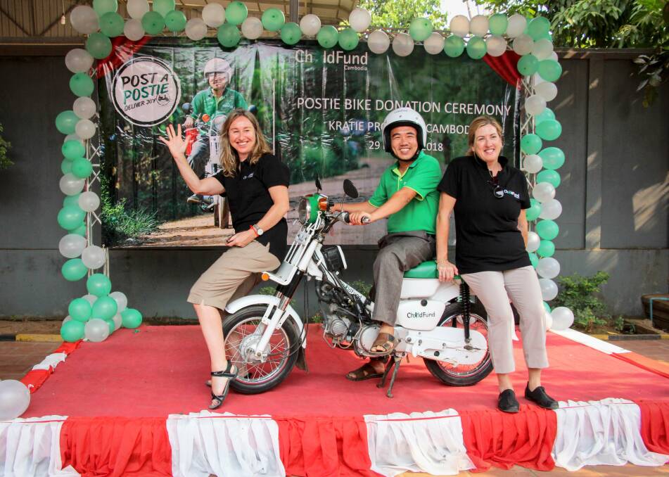 EYE OPENING: Melinda Cox, of Beechworth (left), with the postie bike presented to ChildFund Cambodia staff, a donation from three family groups. The all-terrain bike will allow essential items to be transported more easily.