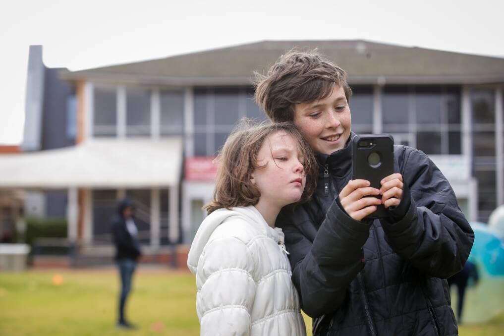 CHECK THIS OUT: Baranduda's Caitlin Knight, 7, watches as her brother Harrison, 12, tries out the Zukaz app at QEII Square Albury on Saturday. Picture: JAMES WILTSHIRE