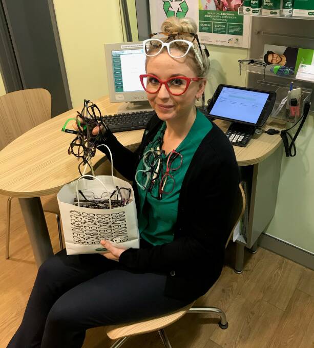GLASSES GRAB: Specsavers Albury optical assistant Amanda Myhill gathers some surplus glasses. Lions Recycle for Sight aims to reduce the number of people facing blindness because they don't have access to corrective lenses.