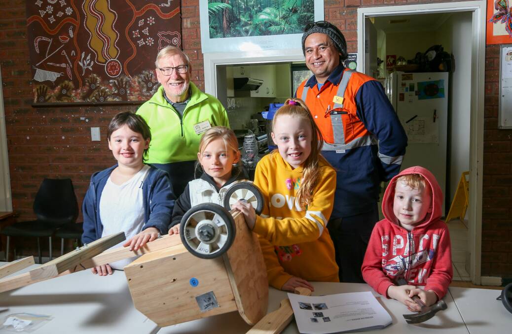 UNDER CONSTRUCTION: Thurgoona Men's Shed members Graham Thring and Soli Tanuvasa oversee Ameyra Fitzgerald, Elizabeth Fitzgerald, Miley Mundy and Eli Ghys as a billy cart takes shape. Picture: TARA TREWHELLA