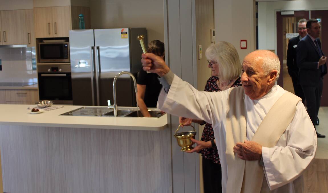 BLESSING: Reverend Father Kevin O'Reilly blesses each room and area of the new small household living homes at Mercy Place Albury on Monday.