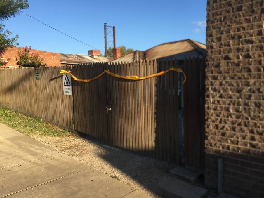 AFTERMATH: A scorched roof can be seen over a taped-off fence in Borella Road, East Albury on Thursday morning.