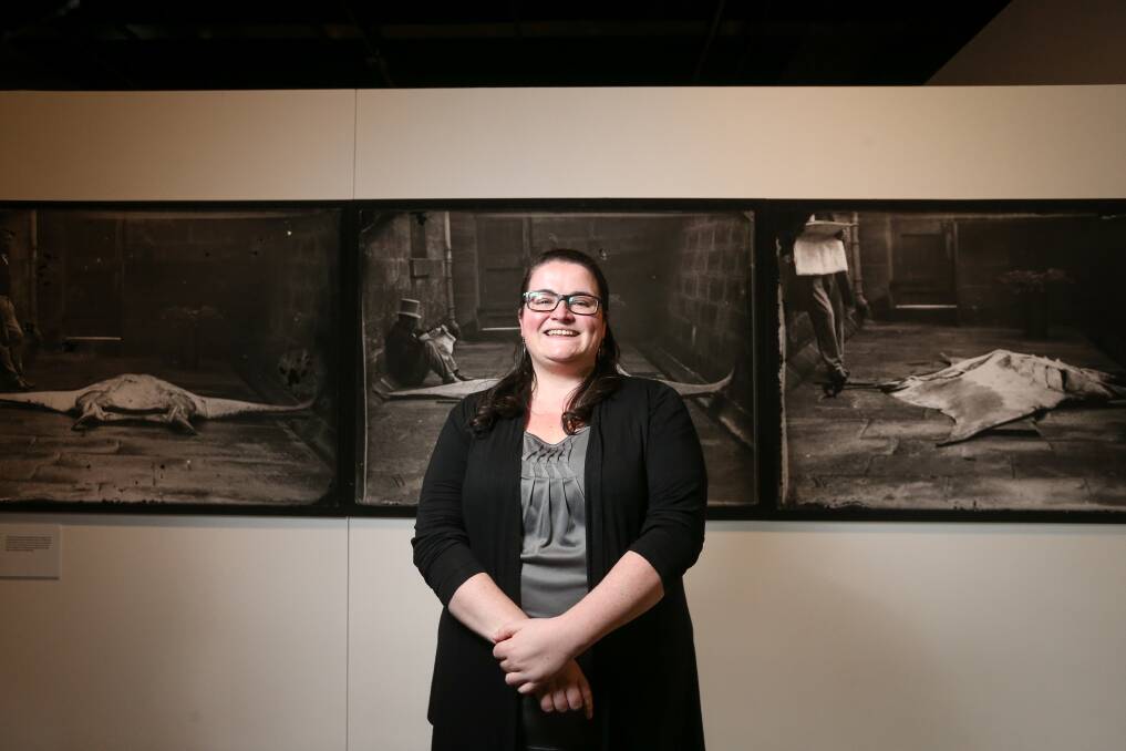 EARLY TECHNIQUES: Kate Eastick in front of three images of 19th century curator Gerard Krefft and a manta ray in the Australian Museum courtyard. Picture: JAMES WILTSHIRE