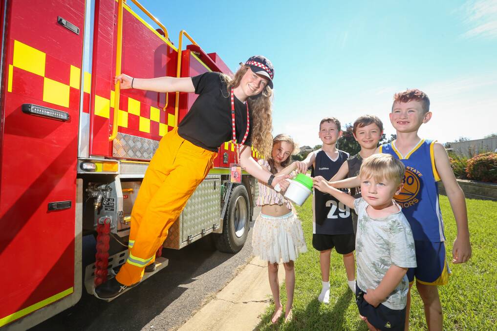 HELPING OTHER CHILDREN: Wodonga West firefighter Lauren Coyle gratefully receives Good Friday Appeal donations from Tayla Rackemann, 8, Harper Attwater, 10, Grady Rackemann, 8, Hudson Attwater, 8, and Ashton Attwater, 4. Picture: JAMES WILTSHIRE