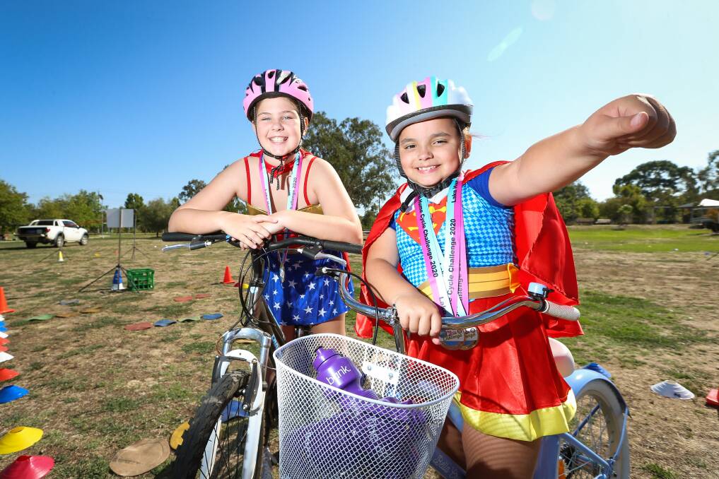 SUPERHEROES: Wonder Woman Harlie Peacock, 11, and Super Girl Charlotte Wilson, 7, celebrate completing the 5km course. Picture: JAMES WILTSHIRE.