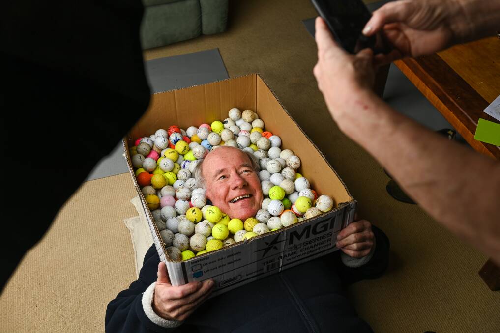 WORK IN PROGRESS: Rotarian Clive Faul proves a good sport, surrounded by golf balls during the Border Mail's photo shoot. Picture: MARK JESSER