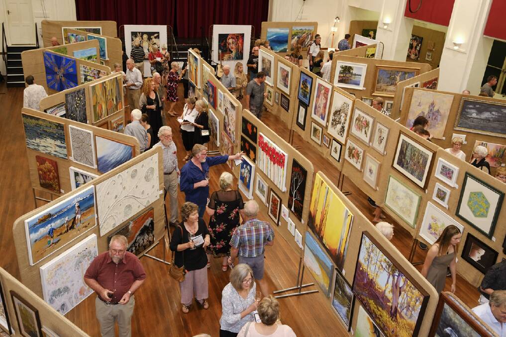 KEEN INTEREST: Art lovers find plenty to see as exhibits fill the hall. Picture: USHI GRANT