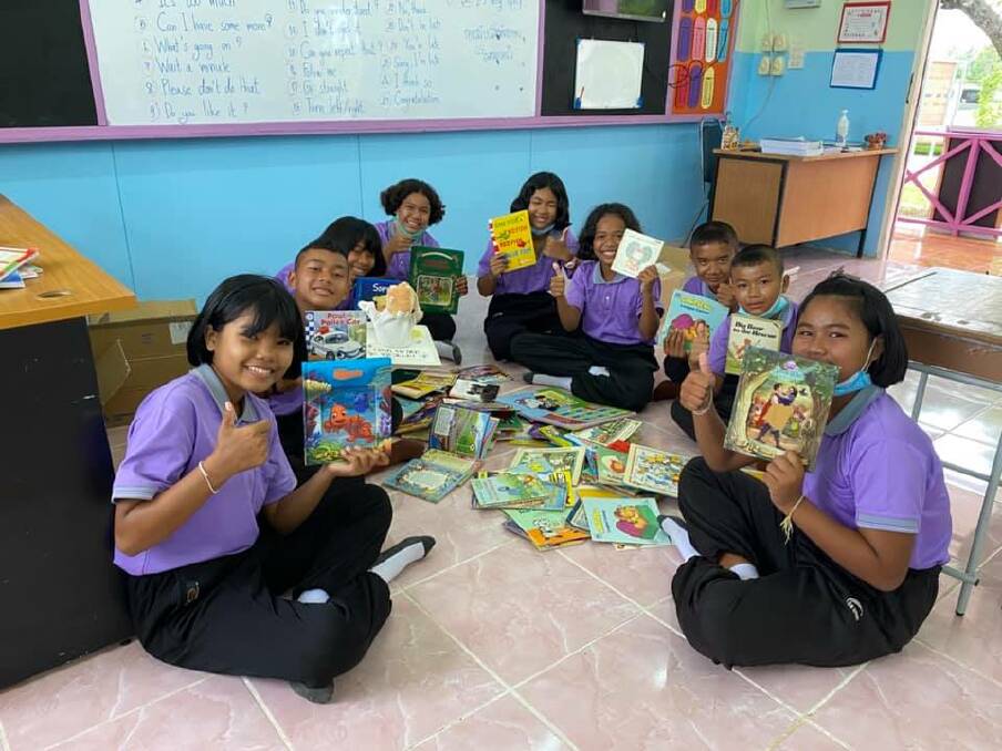 THUMBS UP: Primary school children in Thailand show their approval of the new books.