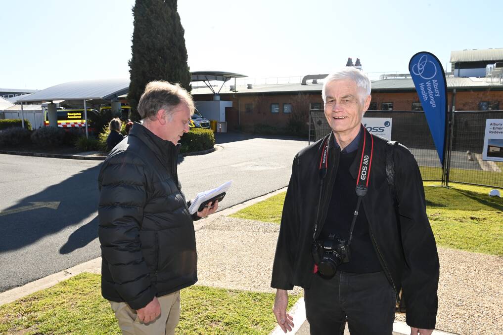 Senior Border Mail reporter Anthony Bunn catches up with former longtime colleague, photographer Peter Merkesteyn, during a visit to Albury by the NSW and Victorian Health Ministers in July 2022.
