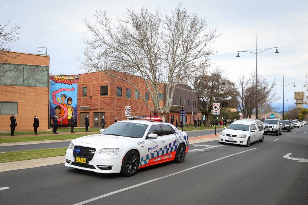 FINAL JOURNEY: Police vehicles escort the hearse past Wodonga Police Station after the funeral of former Senior Sergeant Garry Corcoran, "a dedicated, no-nonsense, commonsense police officer". Picture: JAMES WILTSHIRE