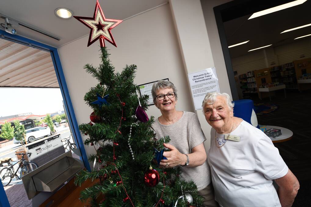 SEASONAL SUPPORT: Wodonga community palliative care team volunteers Christine Gray and Jean Wirges stand with the tree in Wodonga library. Picture: MARK JESSER
