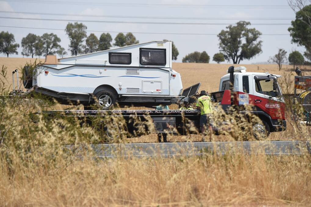 CLEARING UP: Both the car and caravan had to be towed from the scene. Picture: MARK JESSER