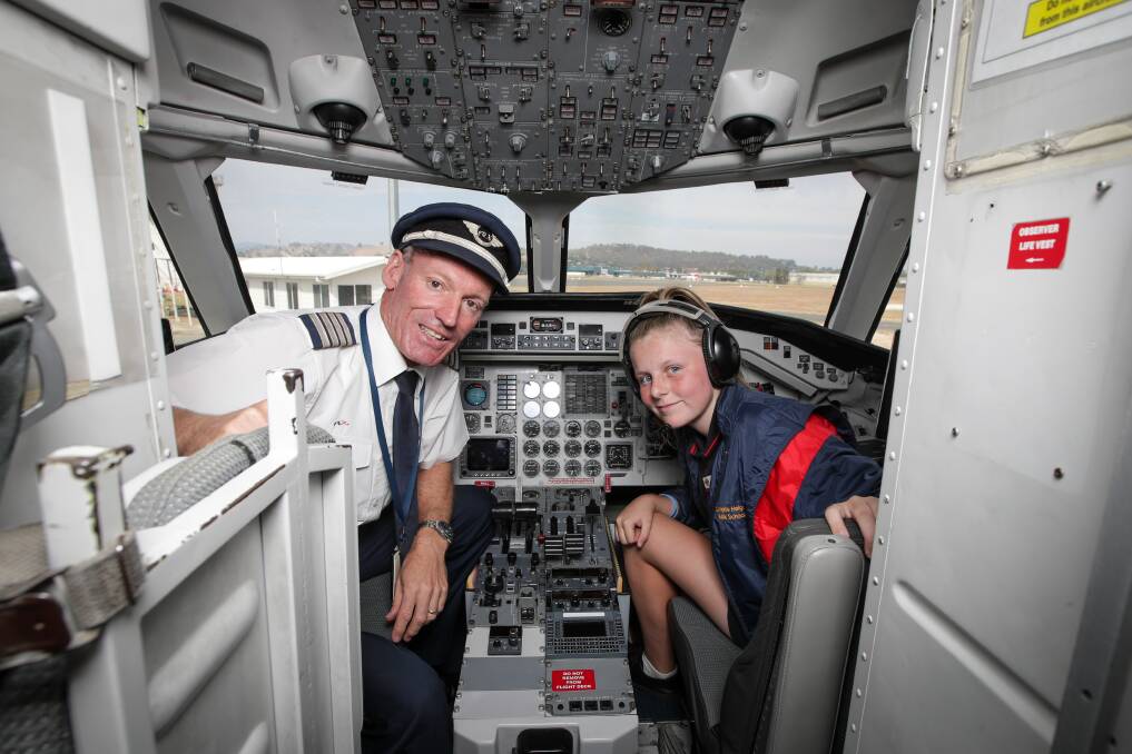 LOTS TO SEE: Captain Ben Jones shows Springdale Heights Public School's Tiana Harmer, 11, the inside of a plane. Picture: JAMES WILTSHIRE