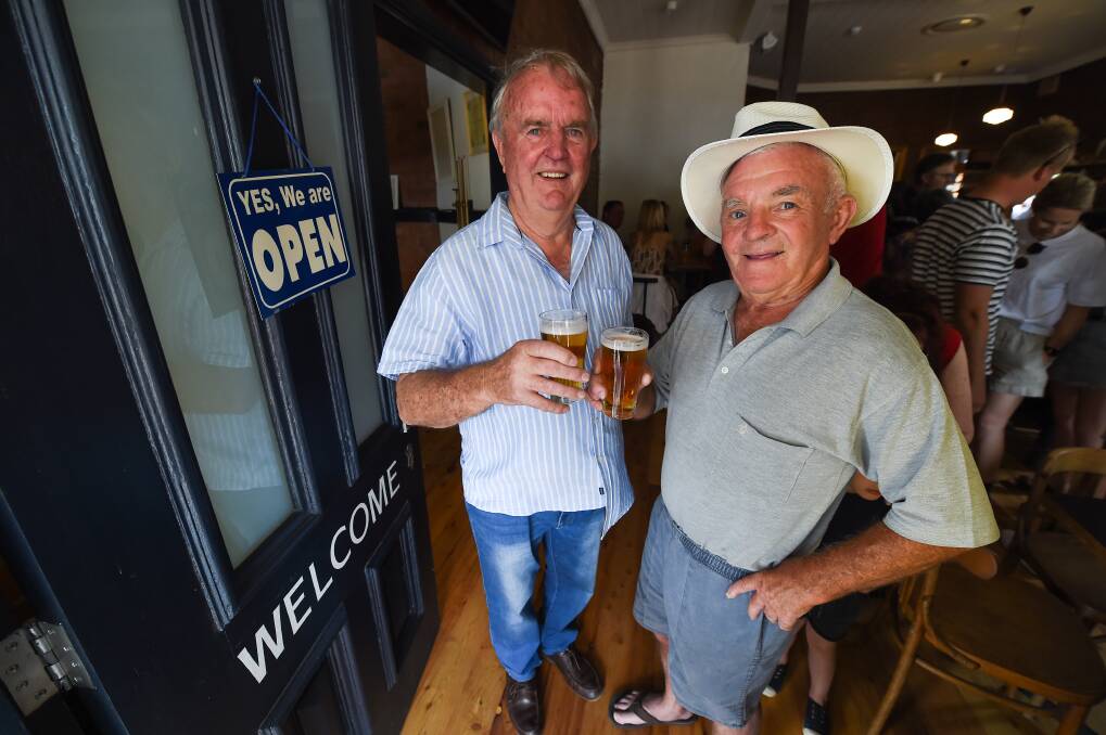 BACK IN BUSINESS: Don Anderson and Mick Seymour toast the return of Balldale Hotel, a venue they've visited often over the years. "A fair bit," Mr Anderson says with a grin. "Reckon I own a few bricks in it." Picture: MARK JESSER