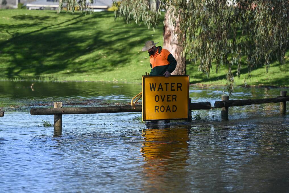 PRECAUTIONS: An Albury Council worker sets up a warning sign for drivers on Monday. Picture: MARK JESSER 