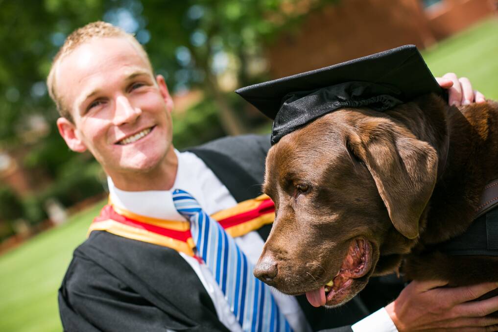 RED LETTER DAY: Daniel Searle graduates from Charles Sturt University in 2014 with Bear by his side.