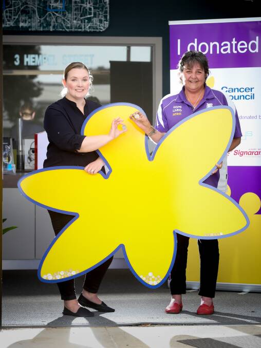 TALKING POINT: Blaze Displays officer manager Jen Mullavey and Waldo's Cans For Cancer's Sharyn Waldron hope this giant daffodil will fill with cash. Picture: KYLIE ESLER