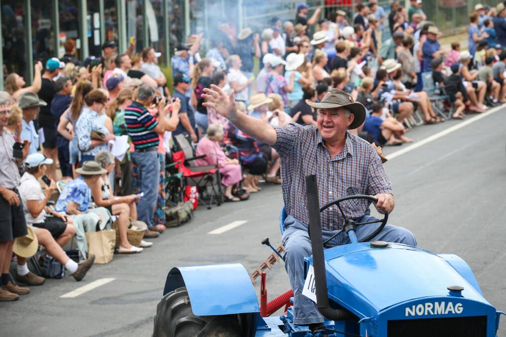 HELLO THERE: Ian Burrowes greets the crowd while driving a 1947 Normag tractor in the street parade. Picture: JAMES WILTSHIRE