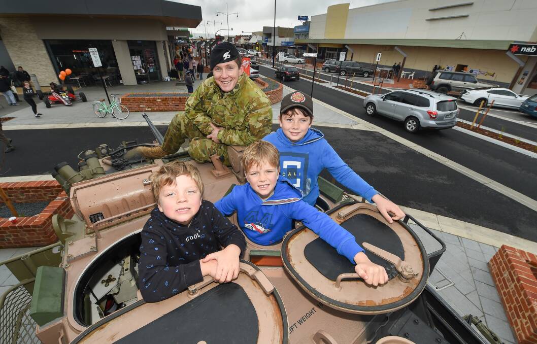 SURVEY SCENE: Wodonga brothers Billy, 5, Charlie, 7, and Zac Chisholm, 9, check out this Australian Light Armoured Vehicle with Trooper Anthony Otto, of Latchford Barracks, during the City Heart Celebration. Picture: MARK JESSER