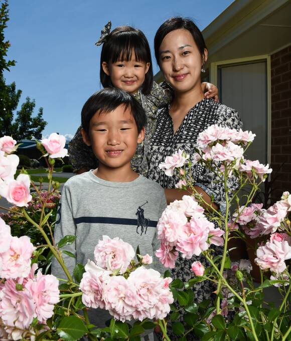 EVERYTHING'S ROSY: East Albury's Junhee Kim and her children Ian, 5, and Dana, 2, look forward to Saturday's Rose-A-Fair. The annual rose show has been held at St David's Uniting Church for about 22 years. Picture: MARK JESSER