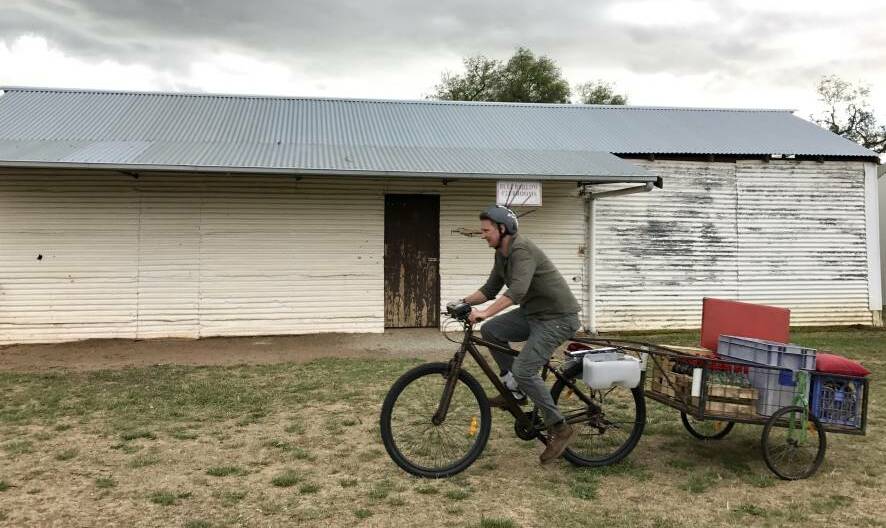 FAMILIAR SIGHT: Damian Callinan as Troy Carrington on his bike, complete with a helmet to ward off swooping magpies. Picture: ALISON PLASTO