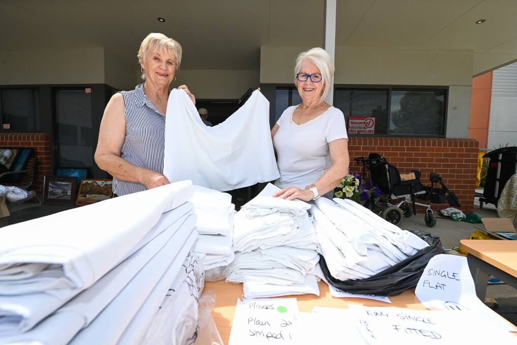 LOTS OF LINEN: Trish Ray and Helen Murray are ready to serve customers at the Hilltop Albury Wodonga Patient and Carer Accommodation Centre sale on Saturday, part of the national Garage Sale Trail. Picture: MARK JESSER