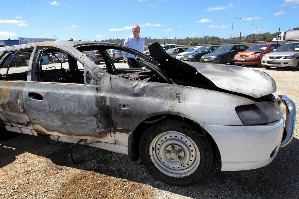 Albury Taxis general manager Tim O’Dea with the cab which was torched in October with only the front number plate able to be salvaged.