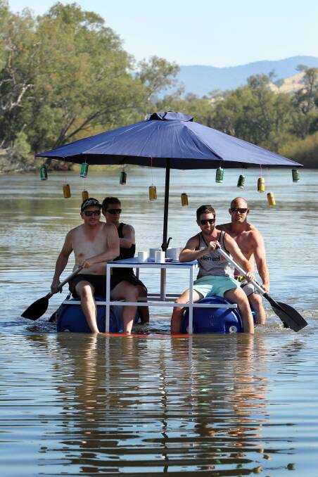 Mates Andrew Dunlop, Chris Allred, Steve Campbell and Joshua Hogg give their floating picnic table a test run at Mungabareena Reserve for their Australia Day float. Picture: MATTHEW SMITHWICK